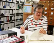 A woman researcher looking through Hokitika Musuem records